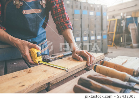 Carpenter working with equipment on wooden table 55432305
