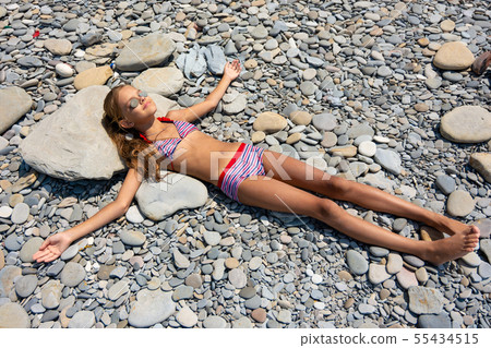 A girl of ten years in a swimsuit lies on the A girl of ten years in a swimsuit lies on the 55434515