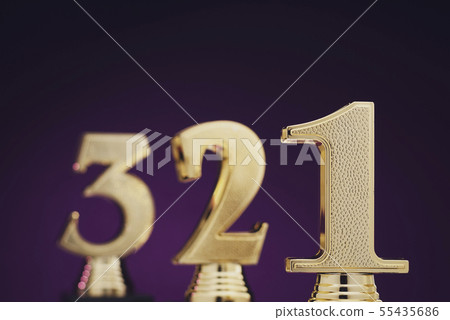 Three golden number trophies in front of blue 55435686