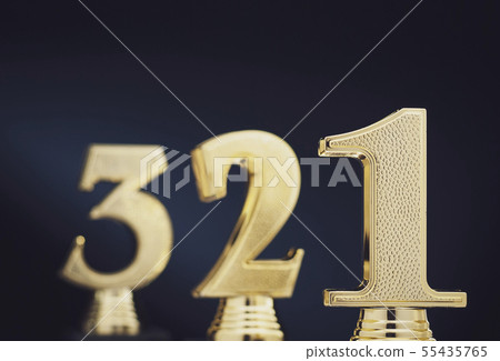 Three golden number trophies in front of blue 55435765