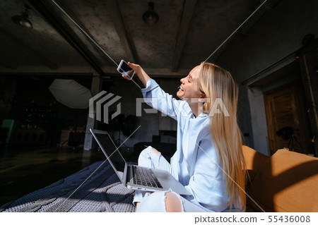 Smiling attractive woman lying on bed talking by smartphone 55436008