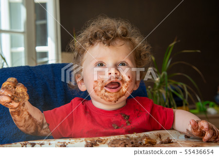 baby is eating a chocolate cake baby is eating a chocolate cake 55436654