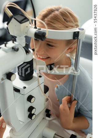 Teenage girl wearing blue sweater coming to ophthalmologist 55437826