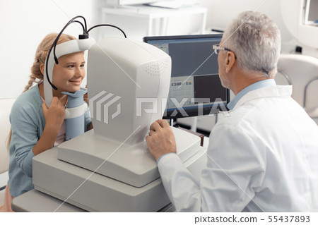 Blonde-haired cute girl smiling while visiting eye specialist 55437893