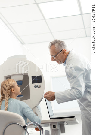 Girl feeling good while speaking to pleasant eye specialist 55437911
