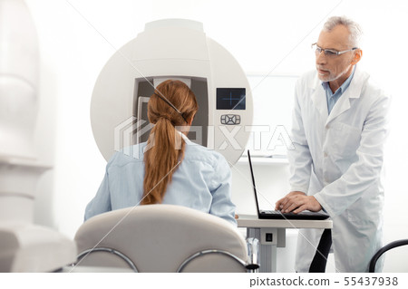 Red-haired businesswoman visiting eye doctor after work Red-haired businesswoman visiting eye doctor after work 55437938