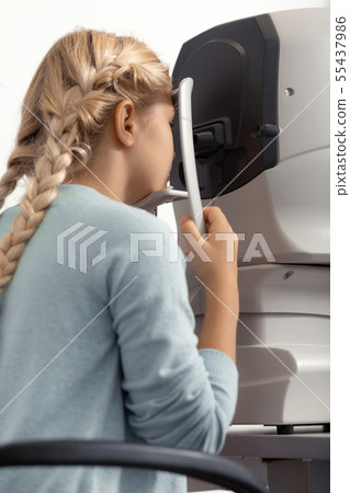 Blonde-haired girl with two braids visiting ophthalmologist 55437986