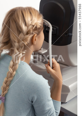 Teen girl wearing blue sweater having eye specialist consultation Teen girl wearing blue sweater having eye specialist consultation 55437988