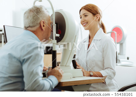 Appealing ophthalmologist smiling while working Appealing ophthalmologist smiling while working 55438101