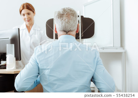 Grey-haired retired man having eye sight analysis at private clinic Grey-haired retired man having eye sight analysis at private clinic 55438254