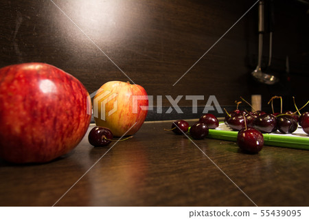 Background of big apples and dark cherries on the Background of big apples and dark cherries on the 55439095