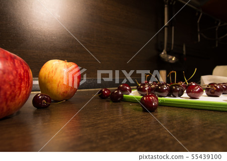 Background apples and dark cherries on the kitchen 55439100