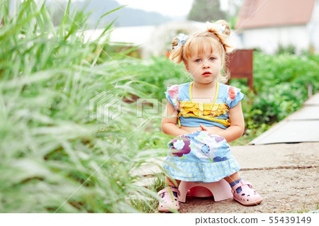 child sitting on a pot in nature child sitting on a pot in nature 55439149