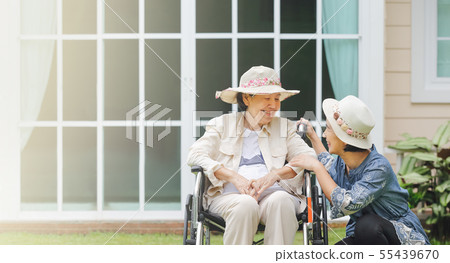 Elderly relax in backyard with daughter Elderly relax in backyard with daughter 55439670