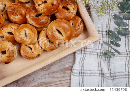 Freshly bun with raisins on a wooden table. Freshly bun with raisins on a wooden table. 55439708