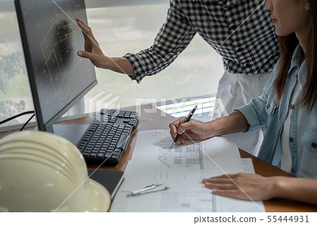 Engineers discuss a blueprint while checking Engineers discuss a blueprint while checking 55444931