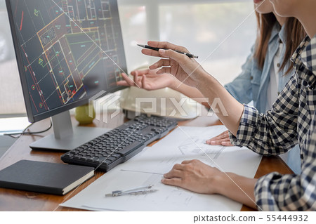 Engineers discuss a blueprint while checking Engineers discuss a blueprint while checking 55444932