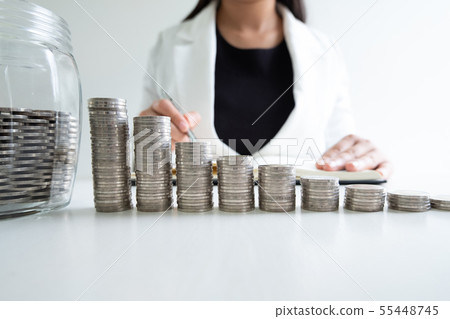 woman hand writing coins in glass bottle bank woman hand writing coins in glass bottle bank 55448745
