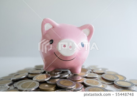 pink piggy bank with coins pile 55448748