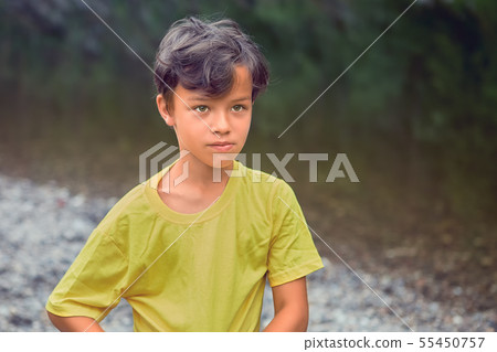 Pensive boy is standing in forest. 55450757