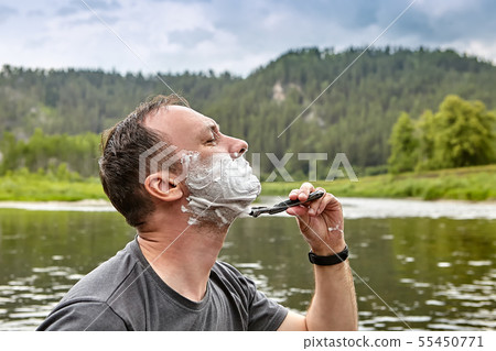 Shaving face in forest during eco-tourism. Shaving face in forest during eco-tourism. 55450771