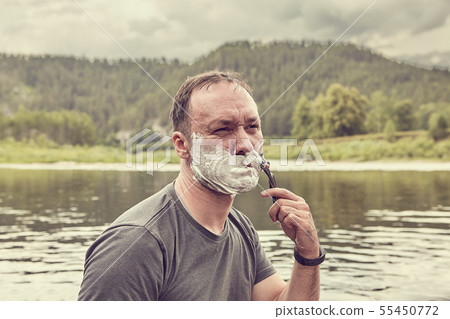 Shaving face in wild nature during ecotourism. Shaving face in wild nature during ecotourism. 55450772