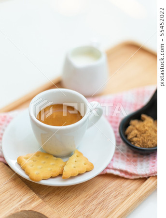 Coffee americano and saucer on a wooden plate with Coffee americano and saucer on a wooden plate with 55452022