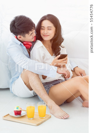 Asian couple sitting on the floor in the bedroom.. Asian couple sitting on the floor in the bedroom.. 55454776