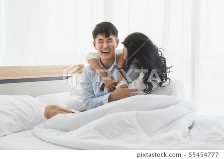 Couple sits on bed, they hug each other by love.. Couple sits on bed, they hug each other by love.. 55454777