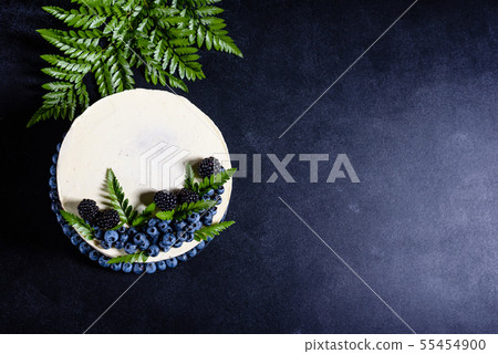 Beautiful tasty cake with white cream and berries  55454900