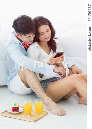 Asian couple sitting on the floor in the bedroom.. 55456417