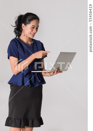 Businesswoman stands and uses notebook computer.. 55456419