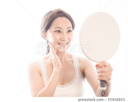 觀看有微笑的中間婦女一個鏡子 55458853