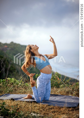 Girl practice yoga near ocean. 55459916