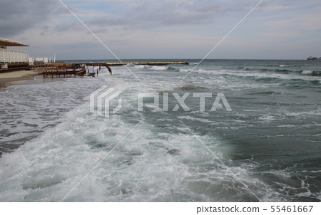 Cloudy weather. Golden sand, waves and foam Cloudy weather. Golden sand, waves and foam 55461667