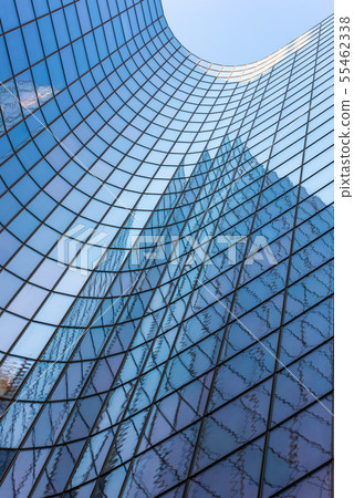 Blue glass skyscraper facade against sky Blue glass skyscraper facade against sky 55462338