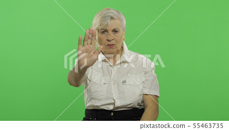 An elderly woman shows a stop gesture. Old grandmother. Chroma key 55463735