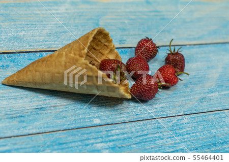 Berry ice cream. Berries of strawberry in a waffle on a blue wooden background Berry ice cream. Berries of strawberry in a waffle on a blue wooden background 55464401