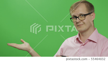Caucasian man in pink shirt showing something. Place for your logo or text 55464832