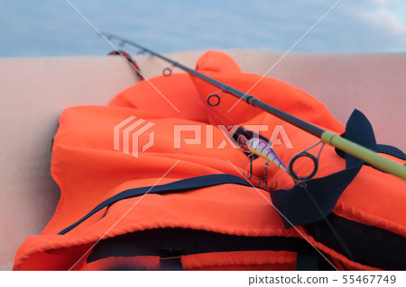 fishing rod on fishing and orange life jacket 55467749