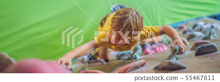 little boy climbing a rock wall in special boots. indoor BANNER, LONG FORMAT little boy climbing a rock wall in special boots. indoor BANNER, LONG FORMAT 55467811