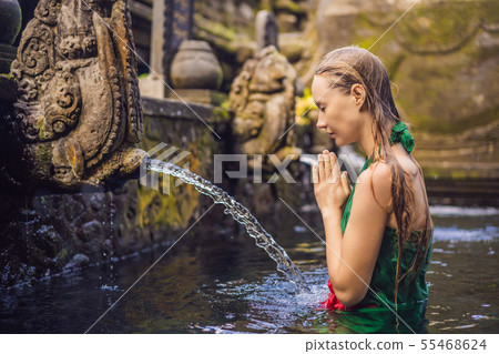 Woman in holy spring water temple in bali. The temple compound consists of a petirtaan or bathing 55468624