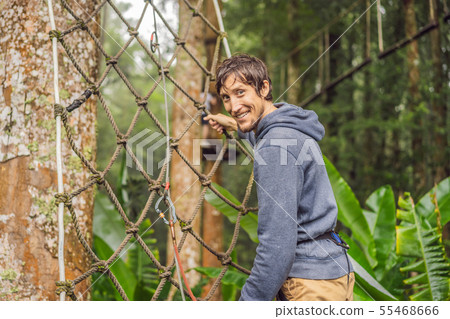 strong young men in a rope park on the wood background 55468666