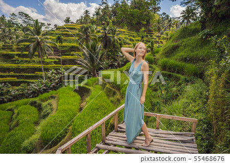 Beautiful young woman walk at typical Asian hillside with rice farming, mountain shape green cascade Beautiful young woman walk at typical Asian hillside with rice farming, mountain shape green cascade 55468676