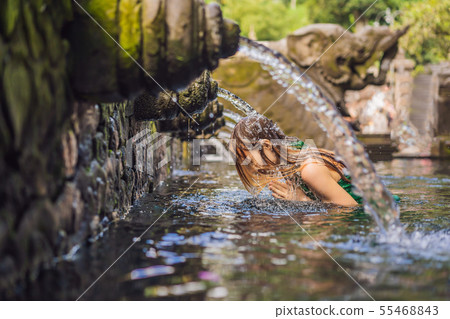Woman in holy spring water temple in bali. The temple compound consists of a petirtaan or bathing Woman in holy spring water temple in bali. The temple compound consists of a petirtaan or bathing 55468843
