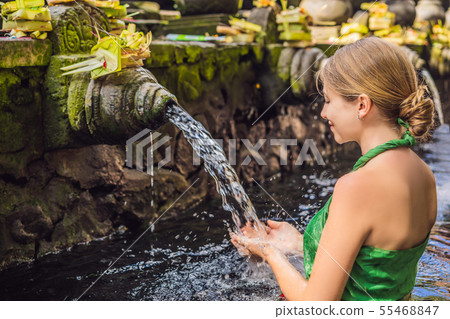 Woman in holy spring water temple in bali. The temple compound consists of a petirtaan or bathing Woman in holy spring water temple in bali. The temple compound consists of a petirtaan or bathing 55468847