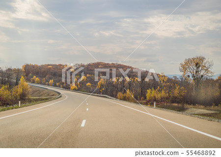 Amazing view with colorful autumn forest with asphalt mountain road. Beautiful landscape with empty 55468892