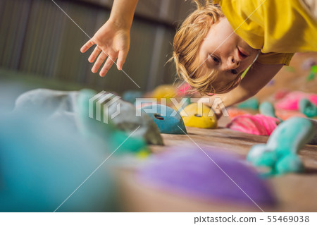 little boy climbing a rock wall in special boots. indoor 55469038