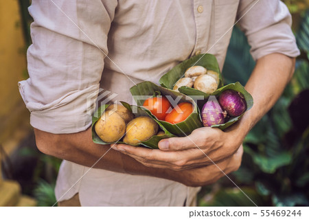 Eco-friendly product packaging concept. Vegetables wrapped in a banana leaf, as an alternative to a 55469244