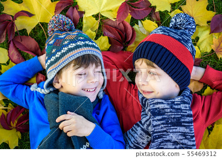 Two little brother kids boys lying in autumn Two little brother kids boys lying in autumn 55469312